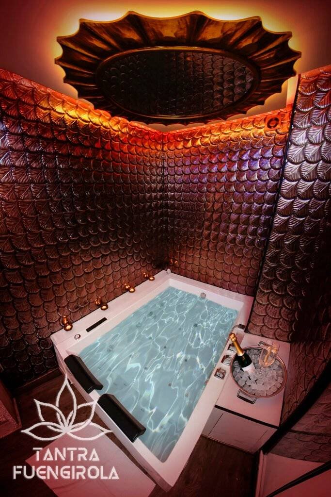 Varmt upplyst jacuzzi och snidad solspegel på vårt center för tantramassage i Fuengirola
